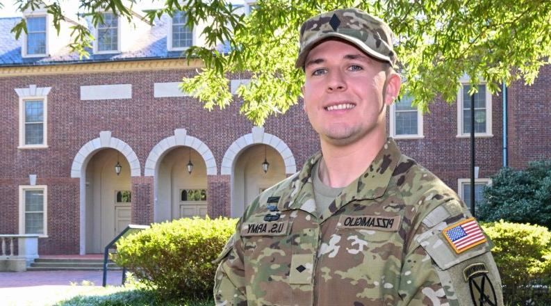 Man dressed in military fatigue and smiling.